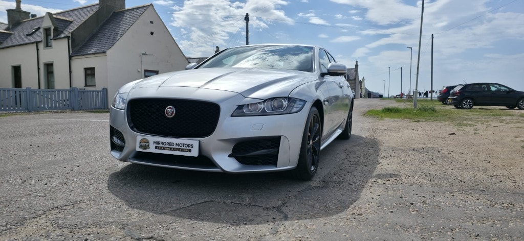 Freshly detailed silver Jaguar XF gleaming on the Moray coast