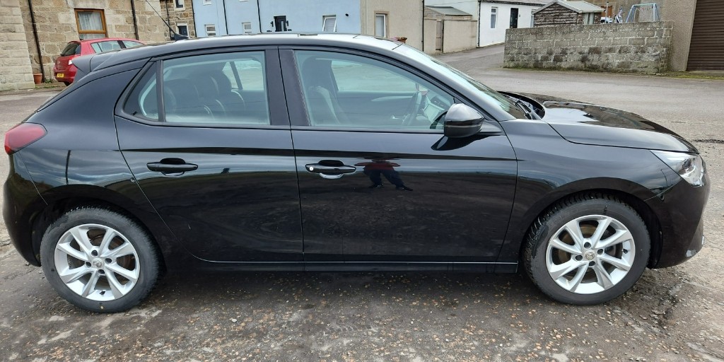 Gleaming black Vauxhall Corsa with a mirror finish after a valet